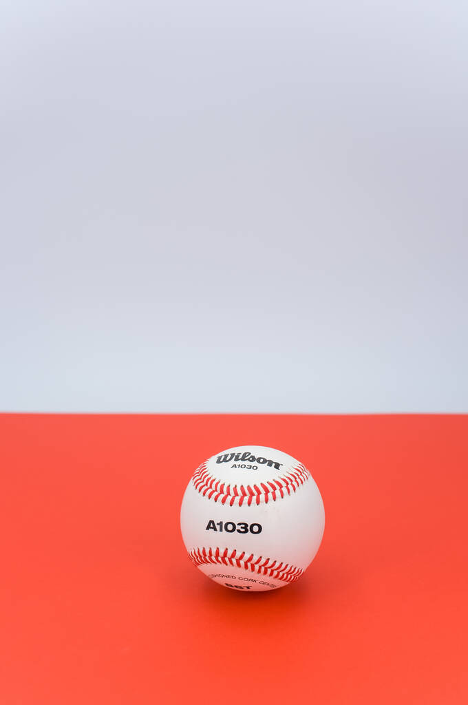 INVERIGO,イタリア- 2021年12月8日:テキスト空間を持つ赤い背景に孤立した野球ボール - 写真・画像