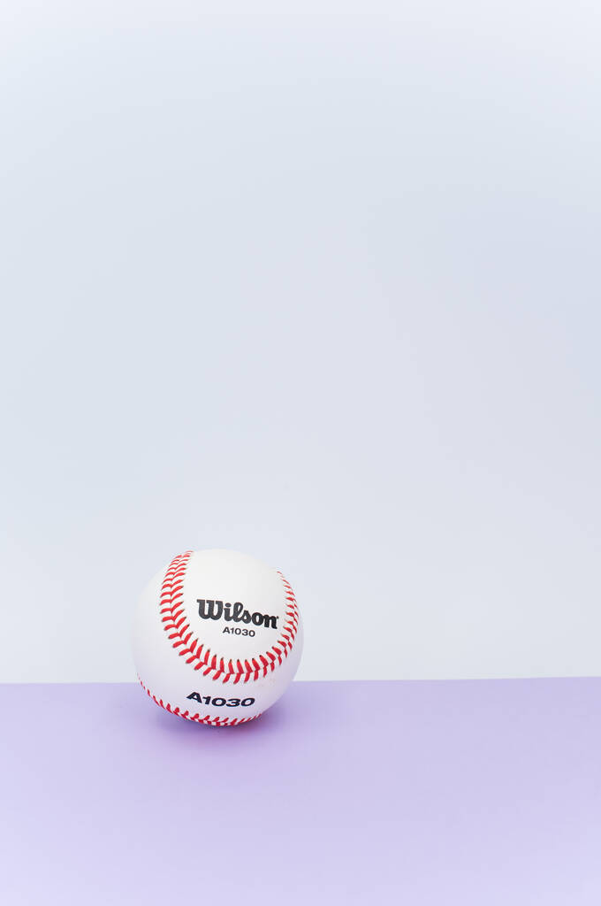 INVERIGO, ITALIA - 08 / 12 / 2021: pelota de béisbol aislada sobre fondo lila con espacio de texto - Foto, Imagen