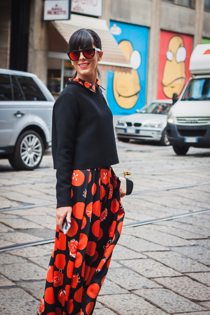 女性がポーズ外ビブロス ファッション ミラノの女性のファッション ・ ウィーク 2014年のための建物を示しています - 写真・画像