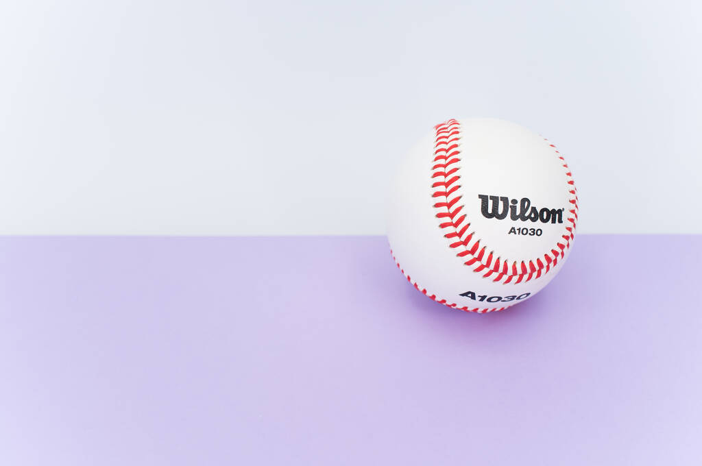 INVERIGO, ITALIA - 08 / 12 / 2021: pelota de béisbol aislada sobre fondo lila con espacio de texto - Foto, Imagen