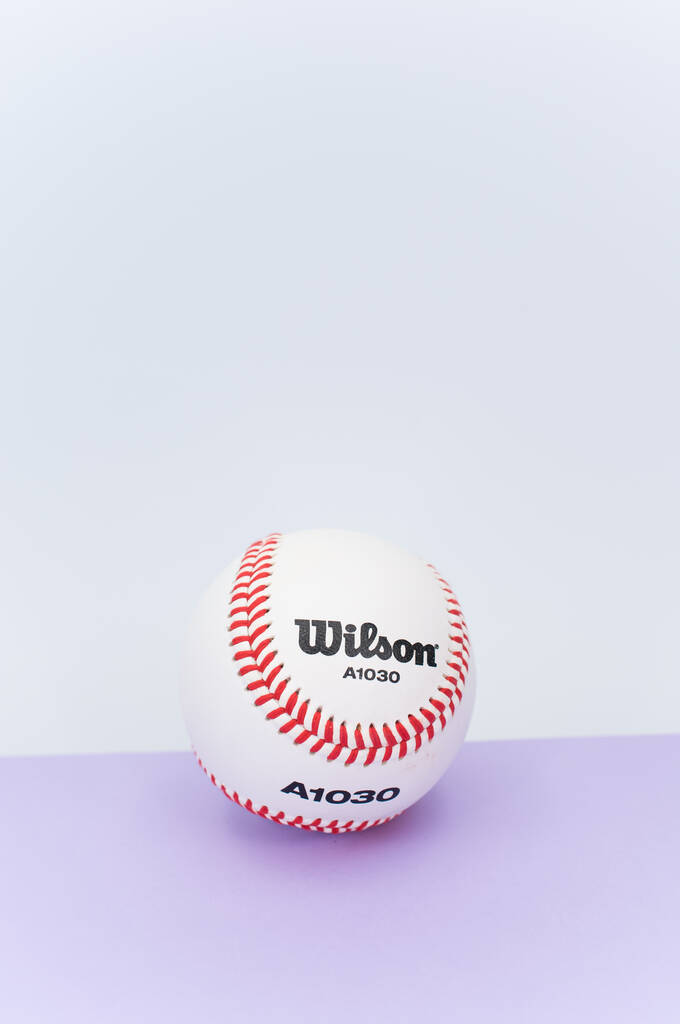 INVERIGO, ITALIEN - 08. Dezember 2021: isolierter Baseballball auf fliederfarbenem Hintergrund mit Leerzeichen - Foto, Bild