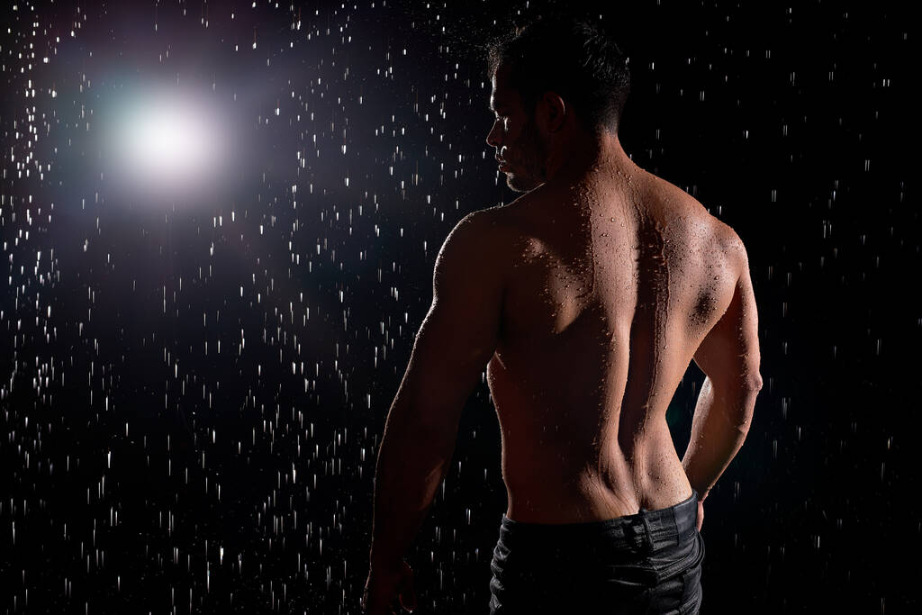 Vista trasera en el hombre atlético muscular sexy con cuerpo fuerte, mostrando la espalda muscular - Foto, imagen