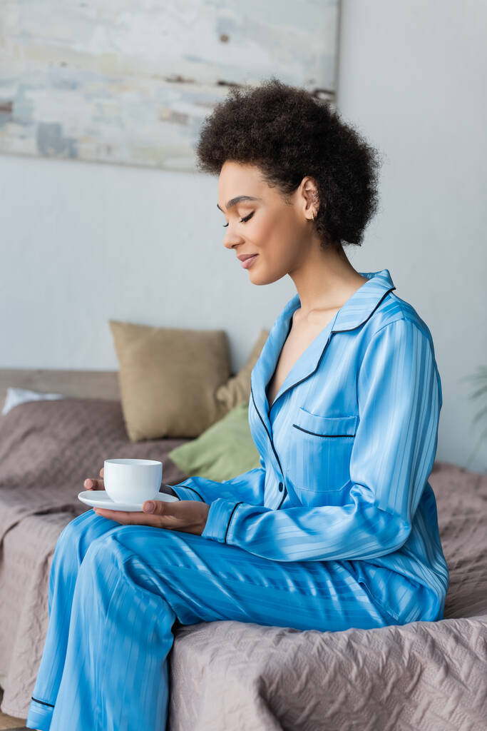 Afroamerykanka w piżamie trzymająca filiżankę kawy  - Zdjęcie, obraz