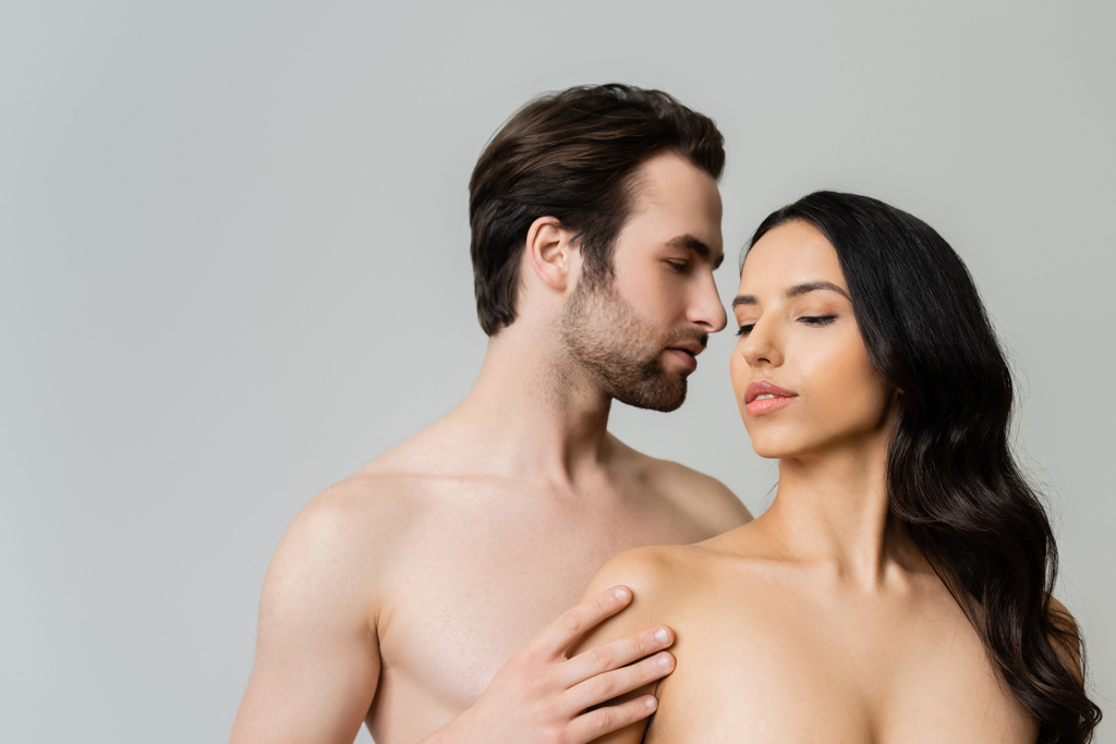 jeune homme torse nu toucher femme brune isolée sur gris - Photo, image