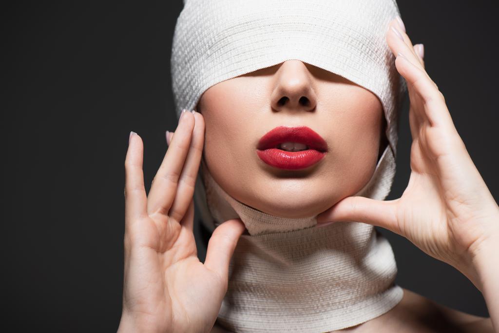 femme en bandage élastique blanc avec les yeux couverts posant isolé sur gris - Photo, image