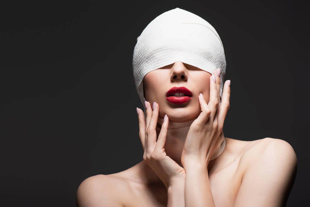 Nainen elastinen side peitetty silmät ja paljaat hartiat eristetty harmaa - Valokuva, kuva