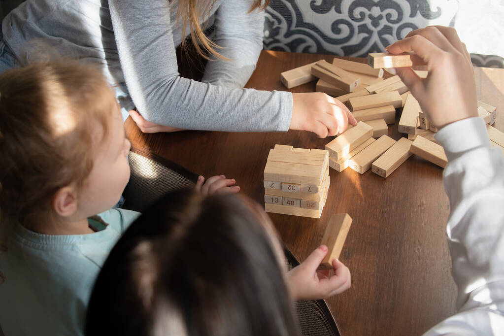 Crianças jogando um jogo de tabuleiro com paus de madeira em casa - Foto, Imagem