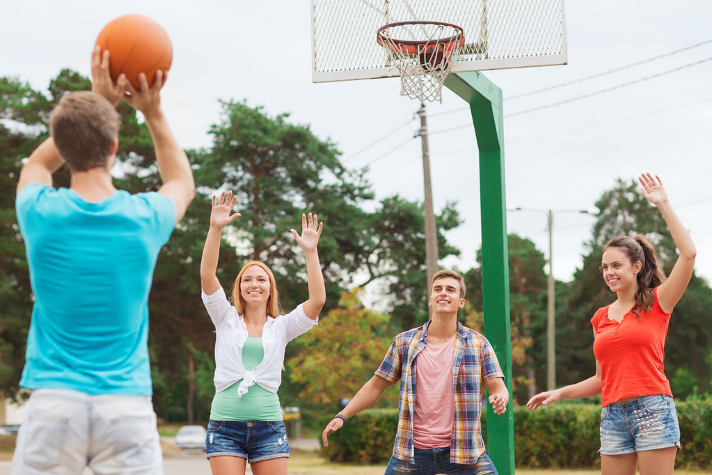 groep van lachende tieners spelen basketbal - Foto, afbeelding