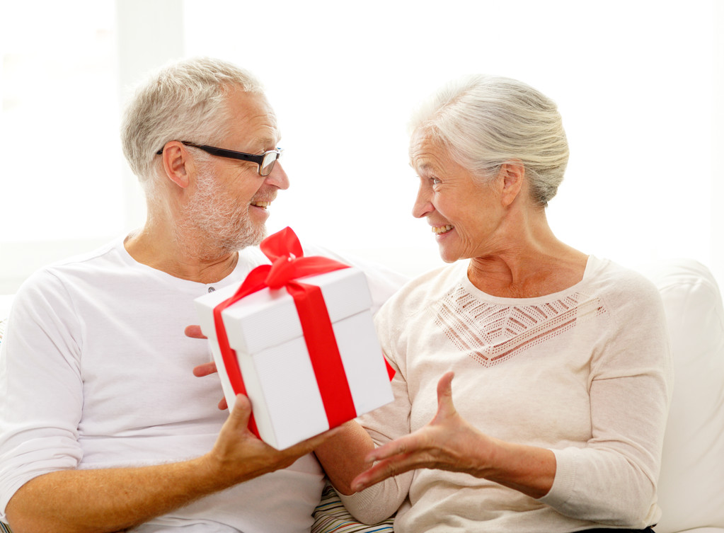 ευτυχισμένο ζευγάρι ηλικιωμένων με κουτί δώρου στο σπίτι - Φωτογραφία, εικόνα