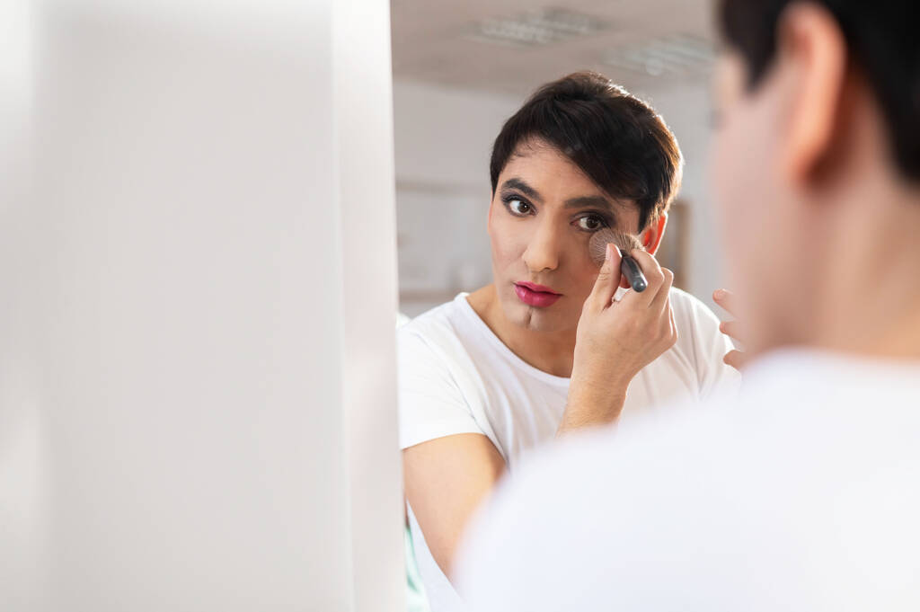 Homosexuál si před zrcadlo nanáší make-up. Mužský transgender. - Fotografie, Obrázek