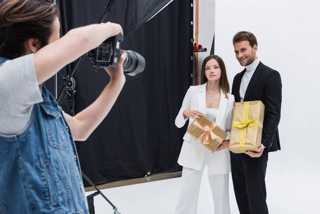 modèles élégants tenant des boîtes-cadeaux tout en posant chez le photographe en studio photo - Photo, image
