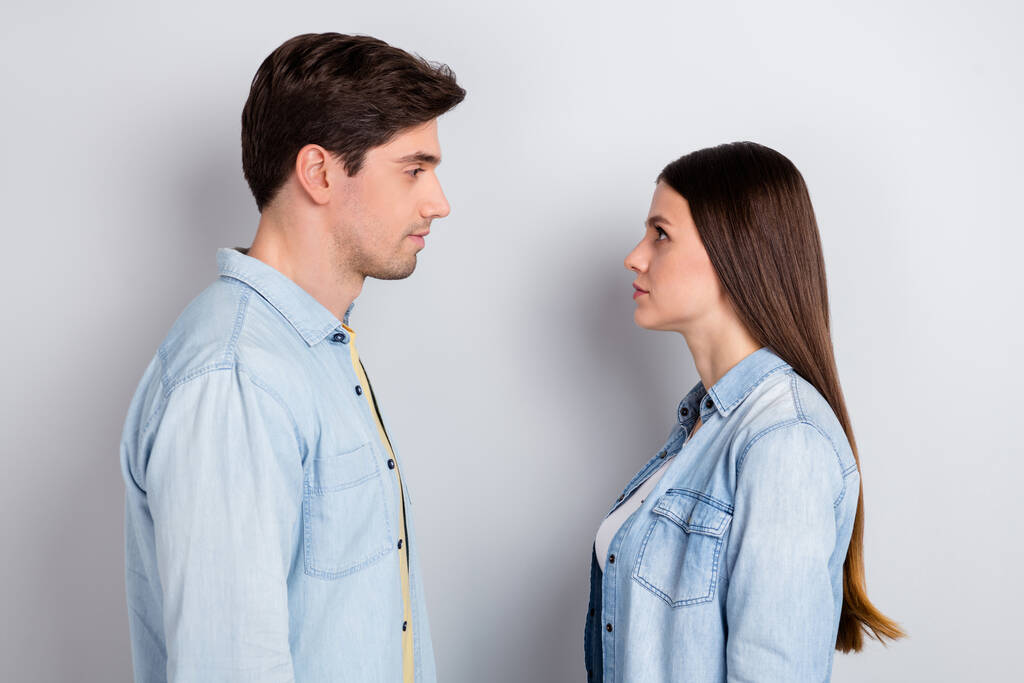 Foto von ernsthaften selbstbewussten Bruder Schwester tragen Jeans-Shirts suchen Augen zu Augen isoliert graue Farbe Hintergrund - Foto, Bild