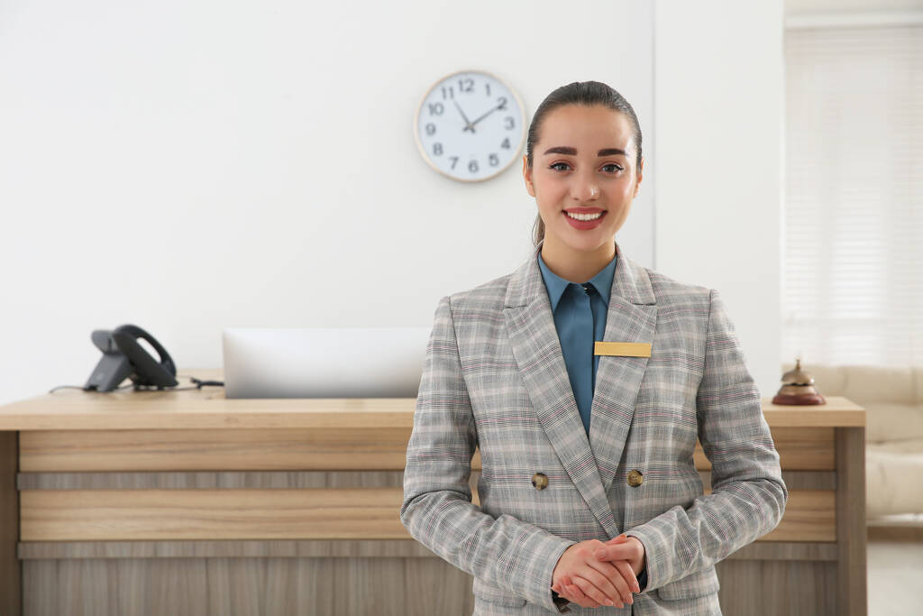 Портрет прекрасной секретарши возле стойки регистрации в отеле - Фото, изображение