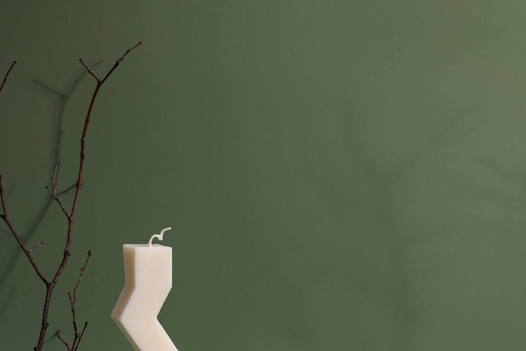 Zigzag kształt świeca sojowa na zielonym tle.Modern domowej roboty świeca, modne hobby  - Zdjęcie, obraz