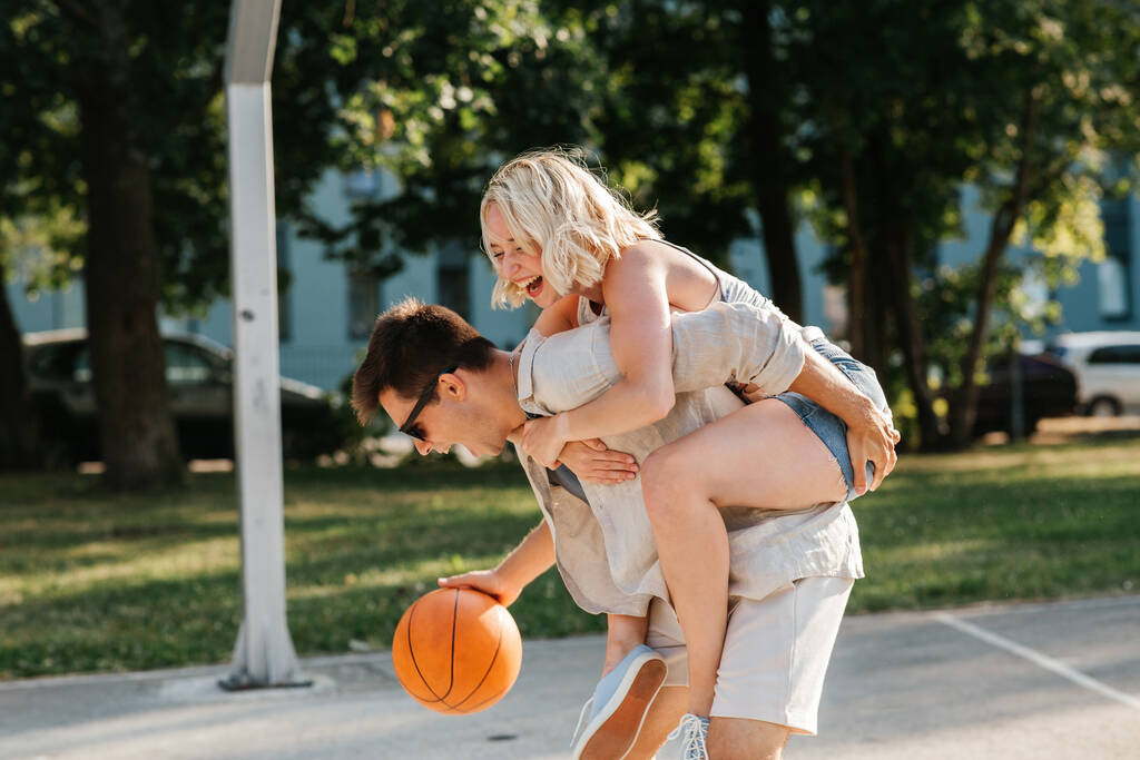feliz pareja divirtiéndose en baloncesto parque infantil - Foto, imagen