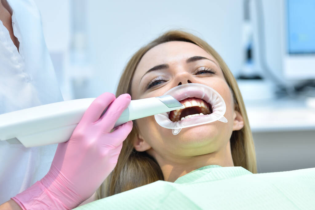 Mulher dentista usando scanner intra-oral dental enquanto examina os dentes do paciente na clínica odontológica. Digitalização intraoral com conceito moderno de máquina de digitalização. - Foto, Imagem