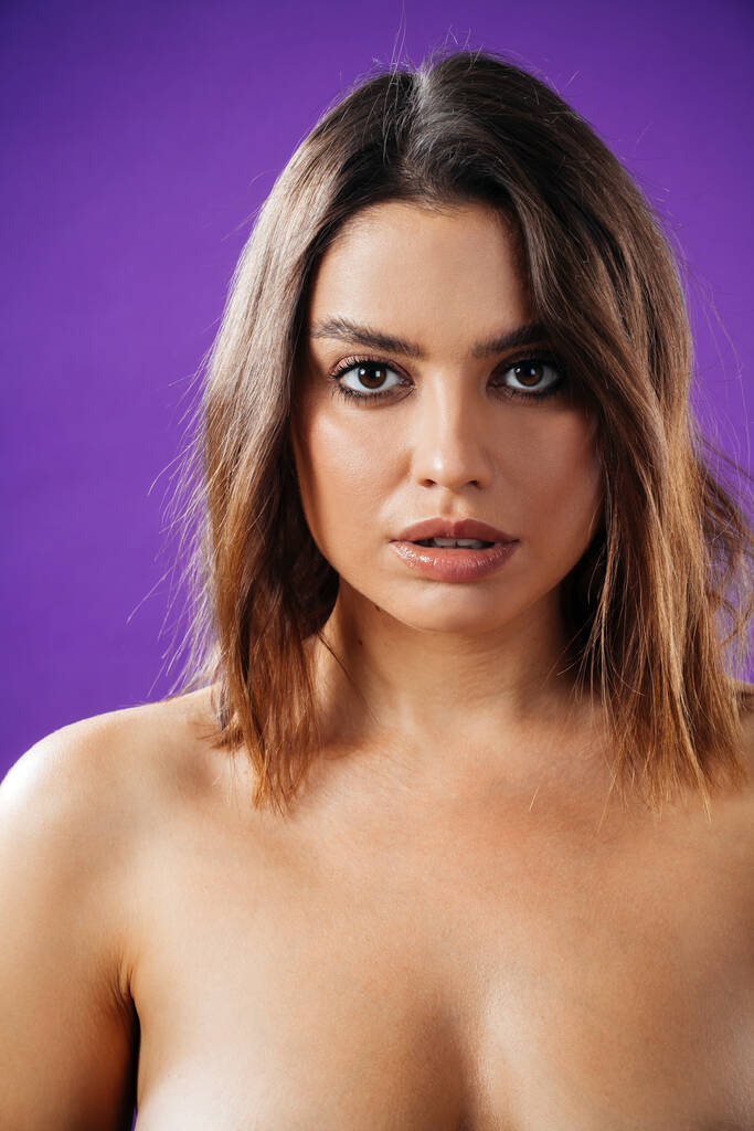 Piękna kobieta topless gapiąca się w kamerę na fioletowym tle. - Zdjęcie, obraz
