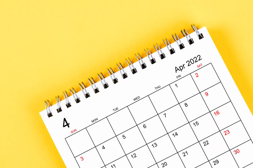 Zbliżenie Kwiecień 2022 biurko kalendarz na żółtym tle. - Zdjęcie, obraz