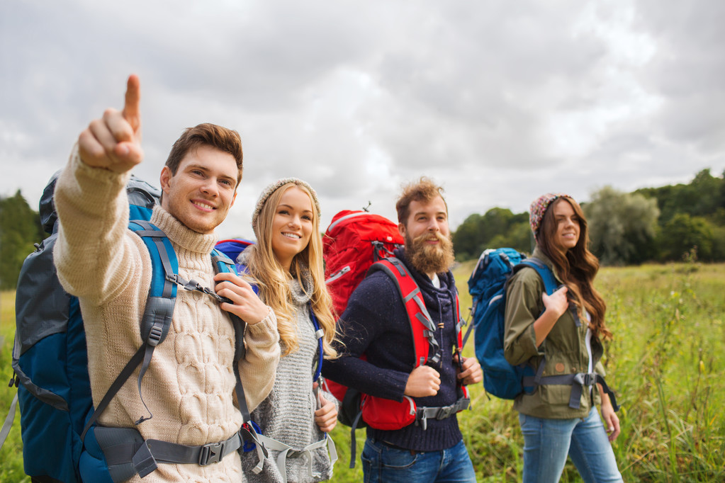 Gruppe lächelnder Freunde mit Rucksäcken beim Wandern - Foto, Bild