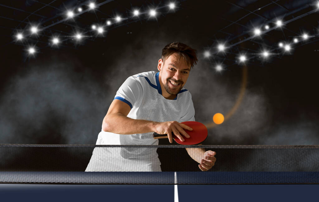 Mann spielt Pingpong auf dunklem Hintergrund  - Foto, Bild