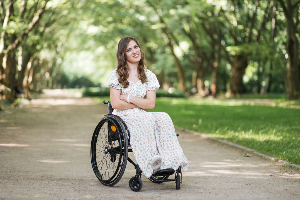 Positieve vrouw in rolstoel poseren op zomerpark - Foto, afbeelding