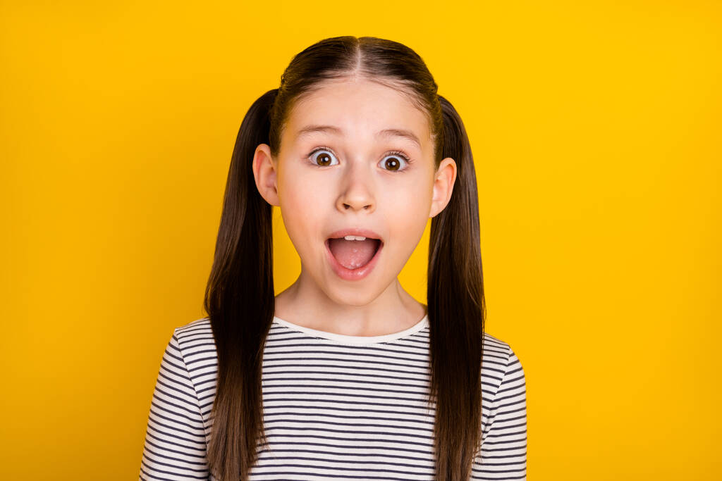 Photo of young attractive school girl amazed shocked surprised fake novelty isolated over yellow color background - Photo, Image