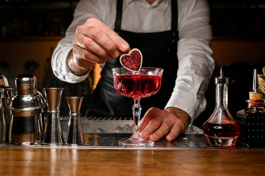primo piano di vetro con cocktail alcolico che il barista maschile dolcemente decora - Foto, immagini