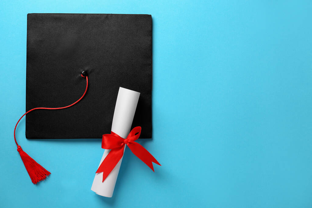 Absolventenhut und Diplom auf hellblauem Hintergrund, flach liegend. Raum für Text - Foto, Bild