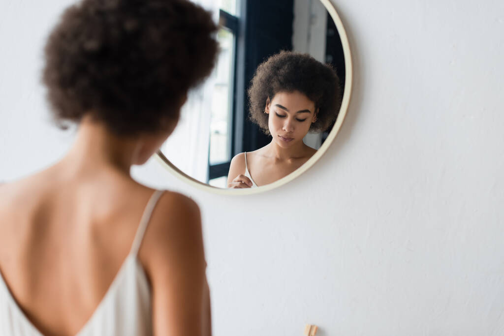 Young african american woman standing near mirror at home  - Photo, Image
