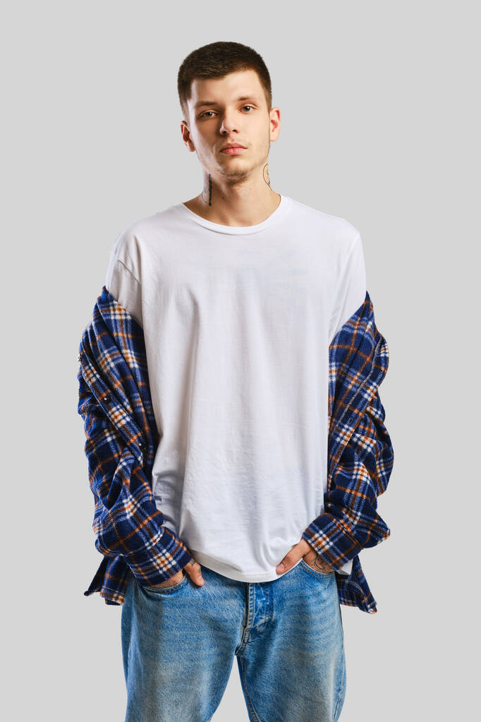 Молодий покидьок в сорочці і джинсах з руками в кишенях
 - Фото, зображення