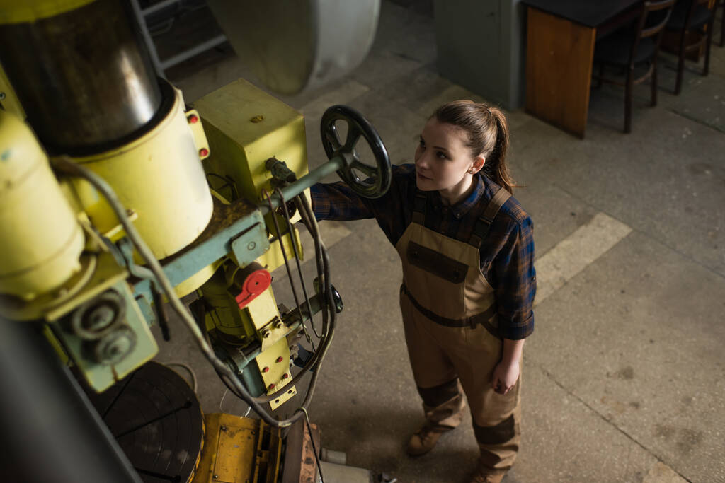A gyári hegesztőgéppel dolgozó fiatal hegesztő felülnézete  - Fotó, kép