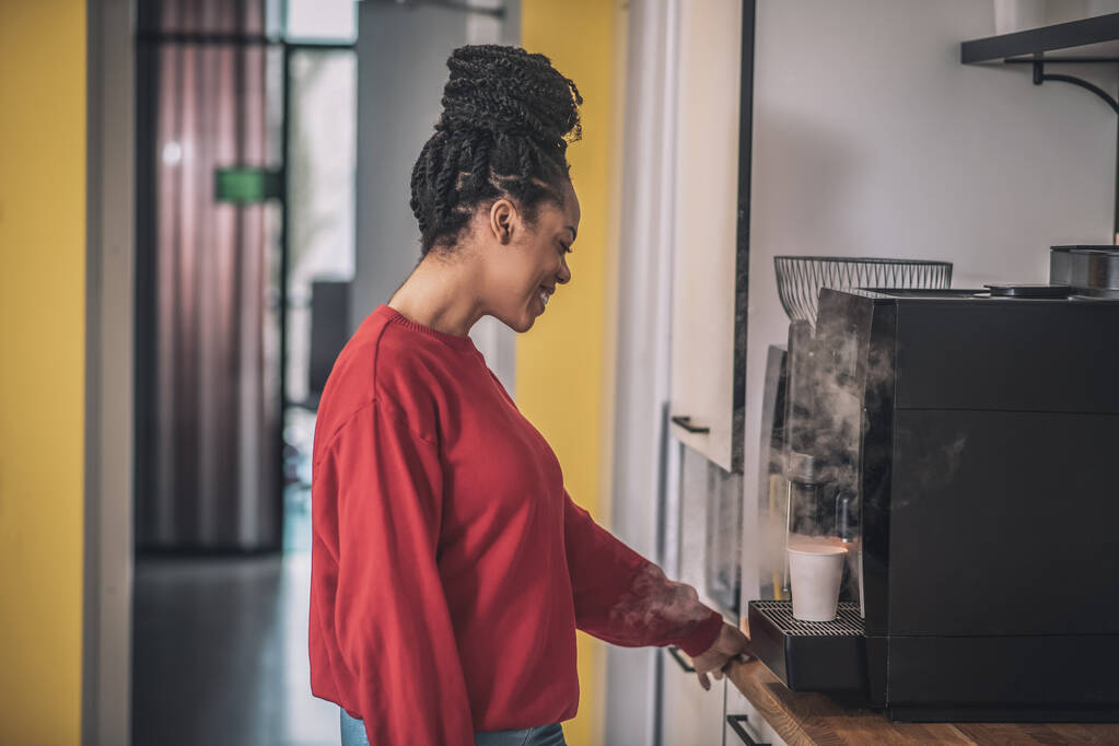 African american girl in profile near coffee machine - Fotó, kép