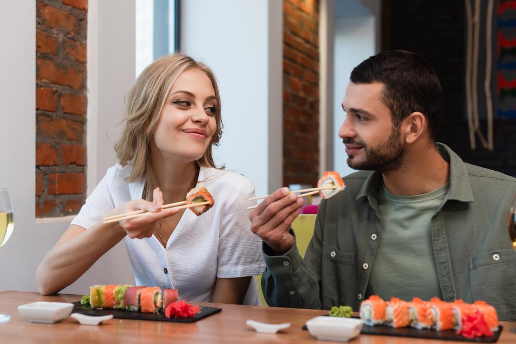 couple heureux se regardant tout en mangeant de délicieux sushis au restaurant - Photo, image