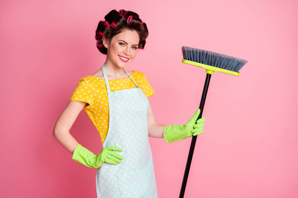 Retrato de la criada experimentada bastante alegre haciendo limpieza ordenada barrido aislado sobre fondo de color pastel rosa - Foto, Imagen