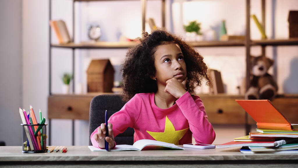 nachdenkliches afrikanisch-amerikanisches Kind macht Hausaufgaben  - Foto, Bild