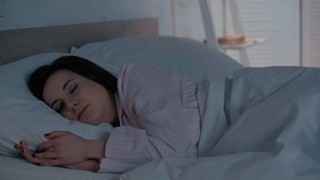 Bruneta žena v pyžamu spí doma na posteli  - Fotografie, Obrázek