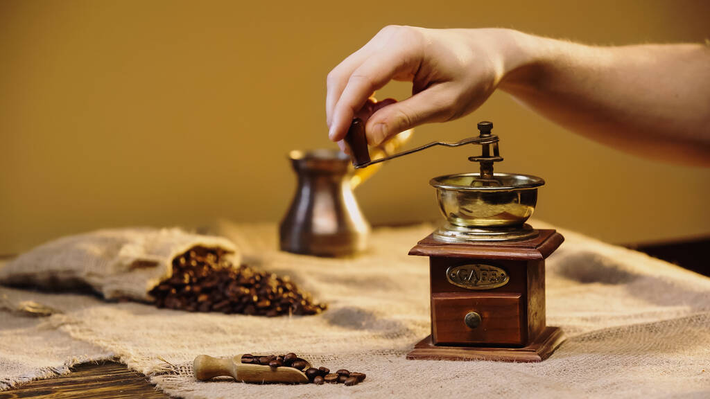 обрізаний вид людини шліфування кавових зерен біля розмитого кавового горщика
  - Фото, зображення