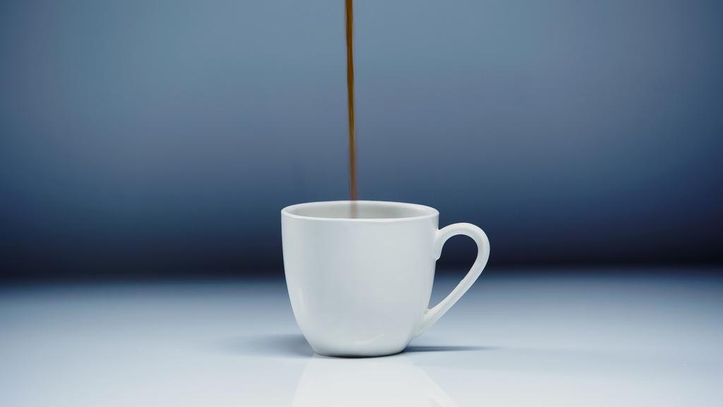 espresso caliente vertiendo en la taza en blanco y gris
  - Foto, Imagen