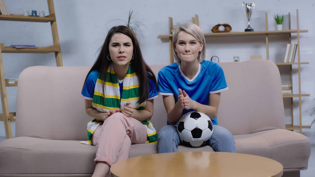 Besorgte Fußballfans verfolgen Meisterschaft in Fußballnähe zu Hause auf Sofa - Foto, Bild
