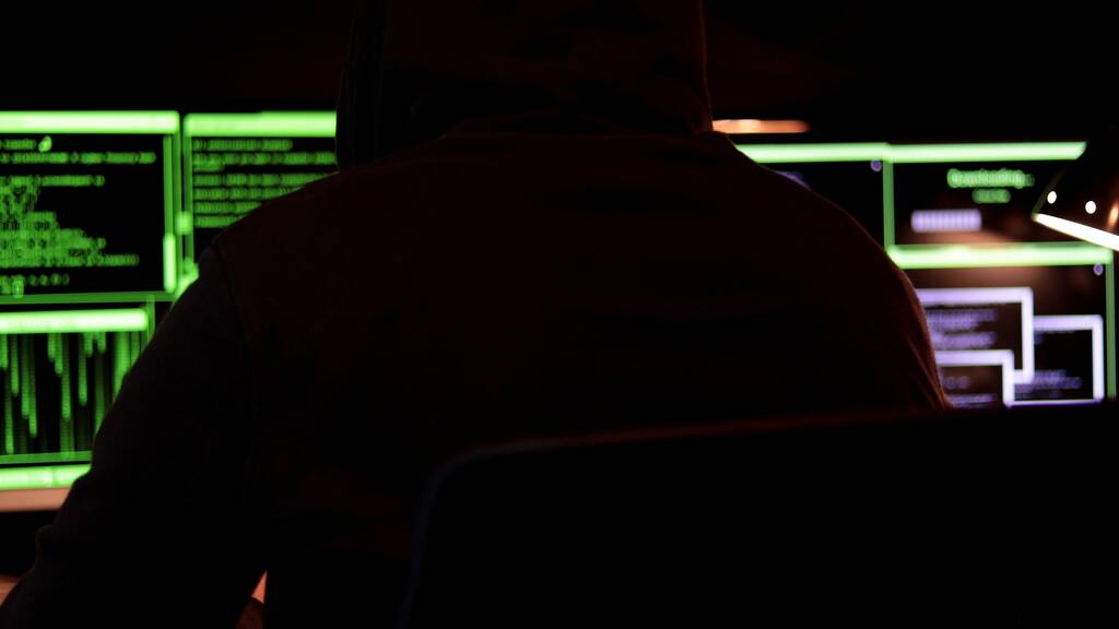 Cyber pirate à capuchon assis examine les données. Entrez des systèmes protégés pour voler de l'argent et de l'information. Concept de cyberterrorisme. - Photo, image