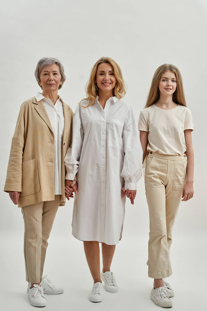 Красивые три женщины стоят и держатся за руки - Фото, изображение