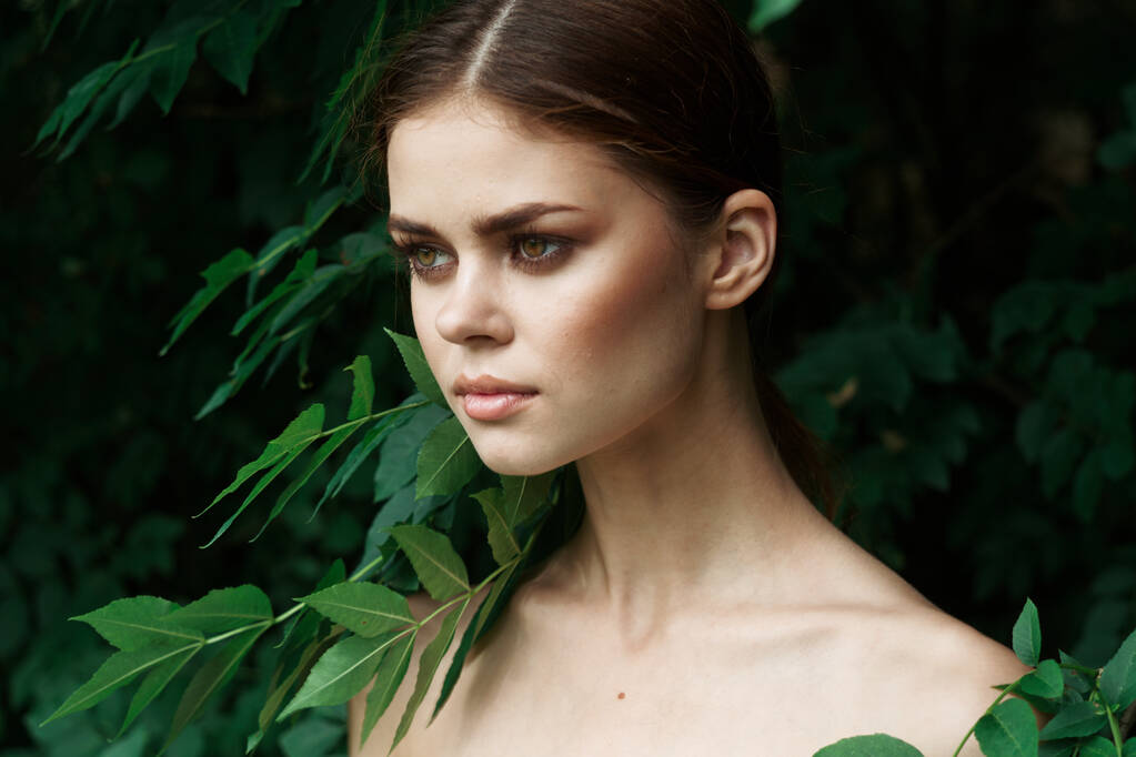 Улыбающаяся женщина зеленые листья чистой кожи Природа летом стиль жизни - Фото, изображение