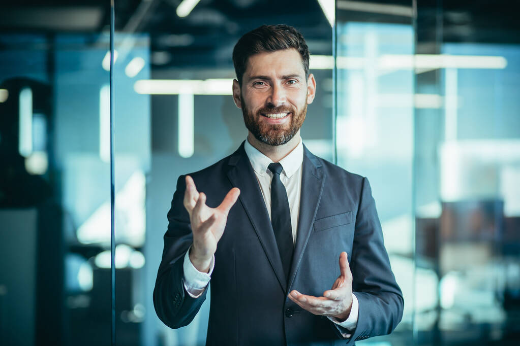 Happy businessman business owner, looking at webcam and holding online meeting remotely, gesturing with hands and smiling at colleagues - Foto, Imagen