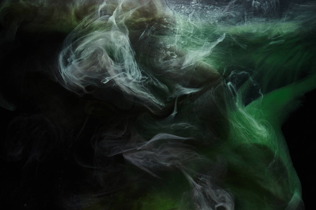 Groene rook op zwarte inkt achtergrond, kleurrijke mist, abstracte wervelende smaragdgroene oceaan, acrylverf pigment onderwater - Foto, afbeelding