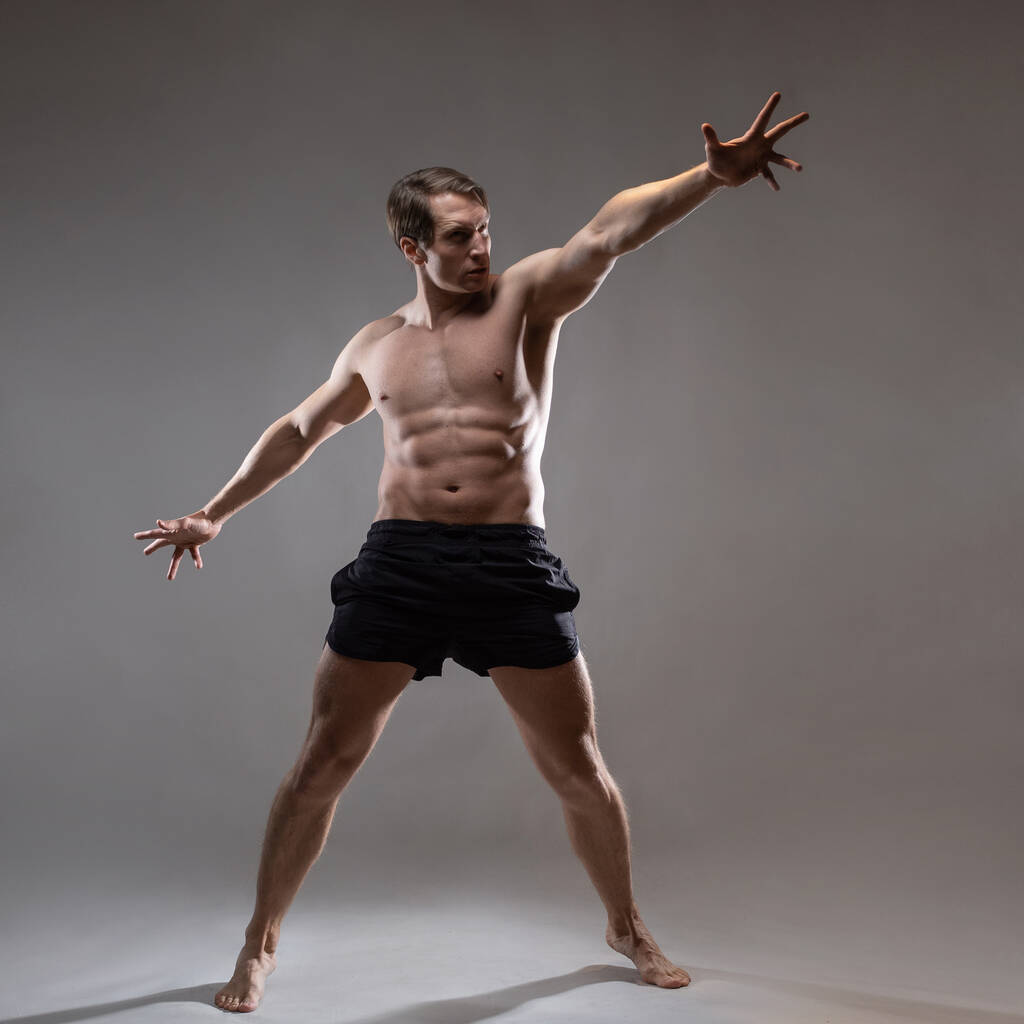 Um jovem homem musculoso em uma pose expressiva. Belos músculos. - Foto, Imagem
