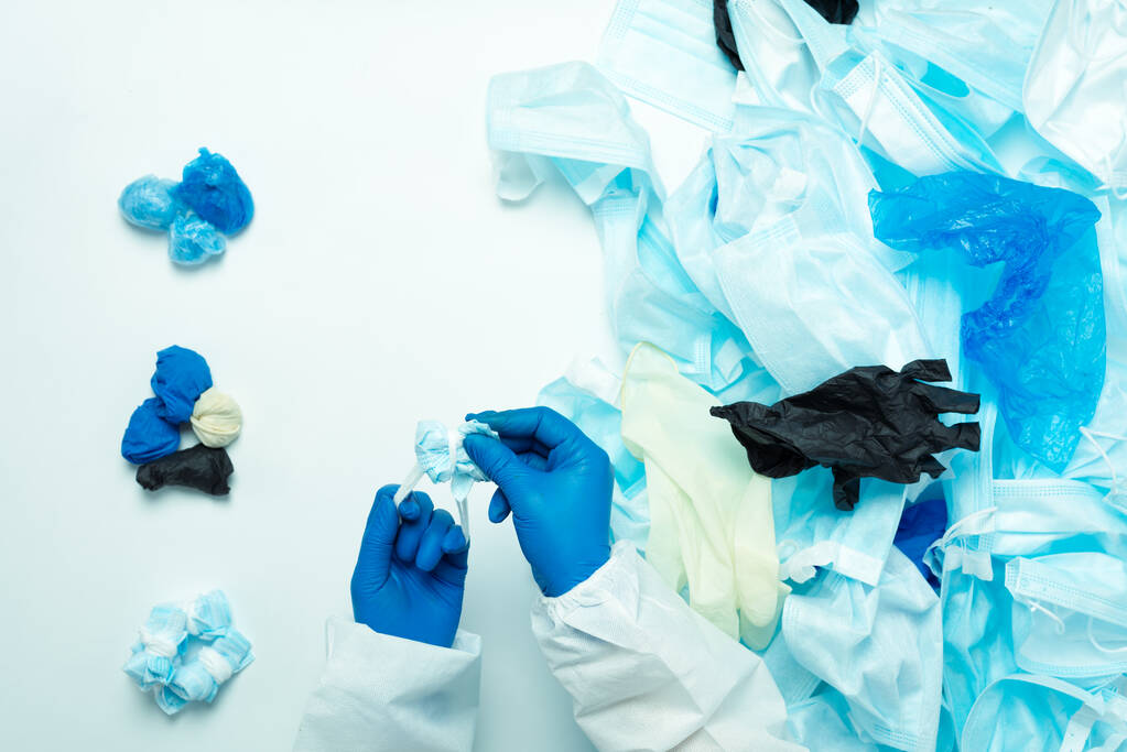 Sorting medical waste after coronavirus. Separate collection of shoe covers, medical gloves and masks. - Photo, Image