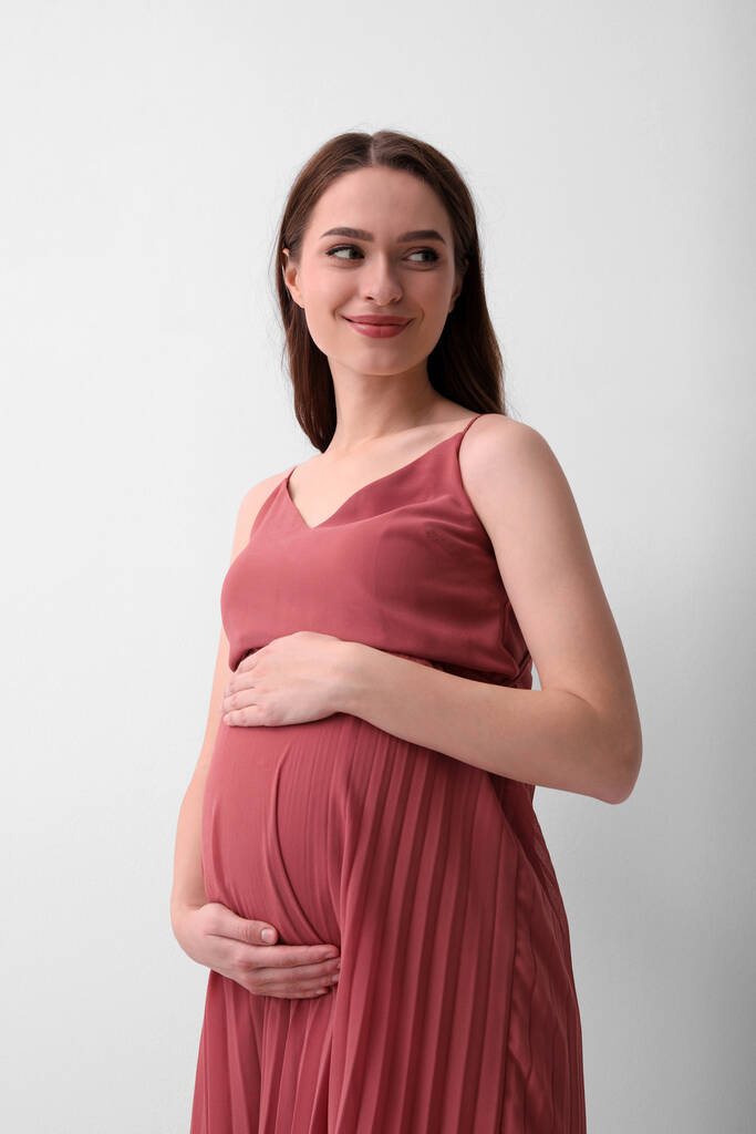 Belle jeune femme enceinte sur fond clair
 - Photo, image
