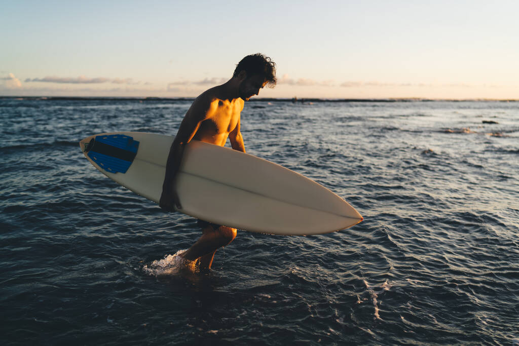 Kaukasische amateur surfer houdt mockup board met kopieerruimte gebied voor reisinformatie wandelen op school op Maldive, sexy man jaren '30 recreëren met hobby krijgen inspiratie op Bali Indonesië - Foto, afbeelding
