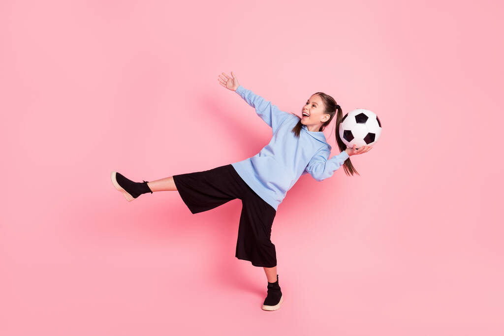 Full length body size photo of schoolgirl in sport outfit throwing ball laughing isolated pastel pink color background - Foto, immagini