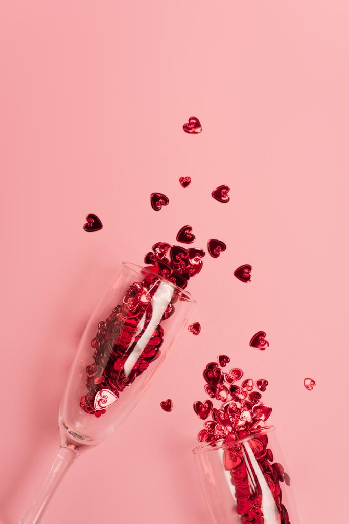 top view of champagne glasses with confetti hearts on pink - Foto, Imagem